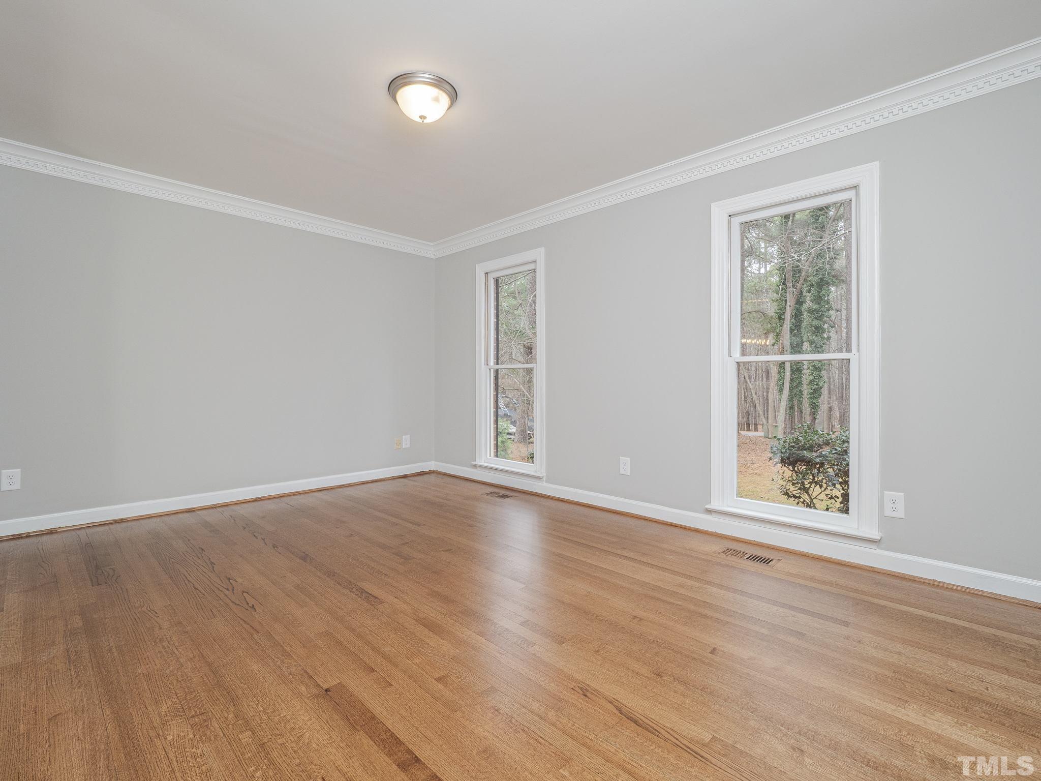9408 Barton Creek Road Raleigh, NC 27615 - Photo 7 of 20 a view of an empty room with wooden floor and a window