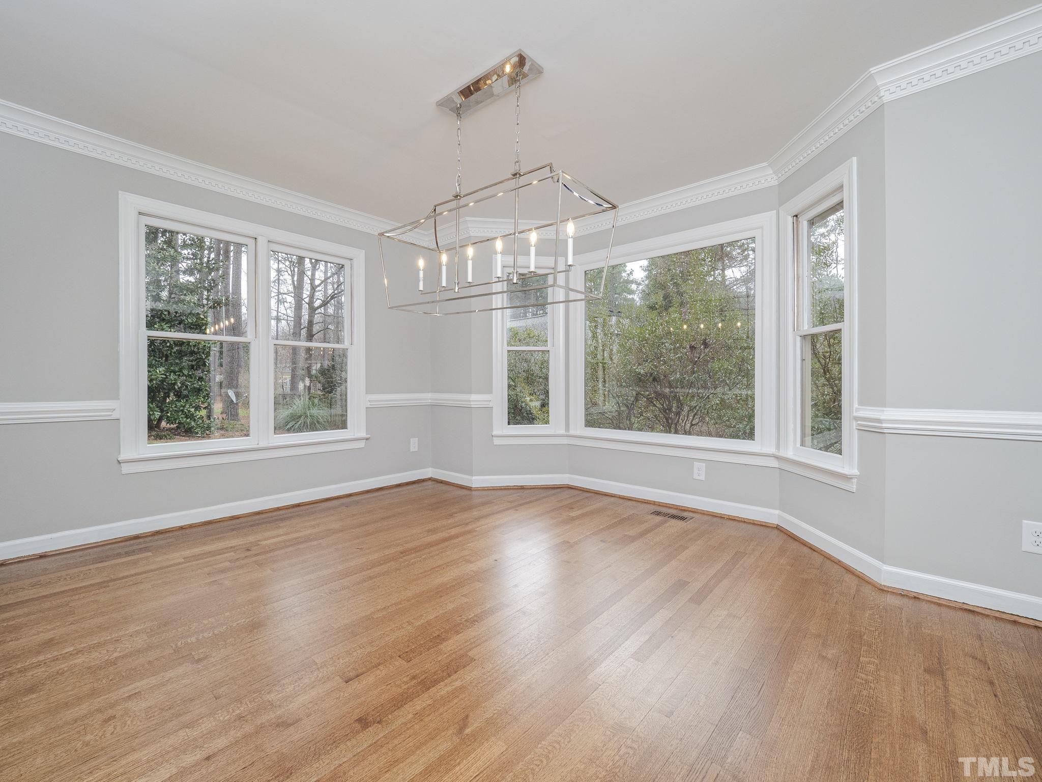 9408 Barton Creek Road Raleigh, NC 27615 - Photo 8 of 20 a view of an empty room with wooden floor and a window