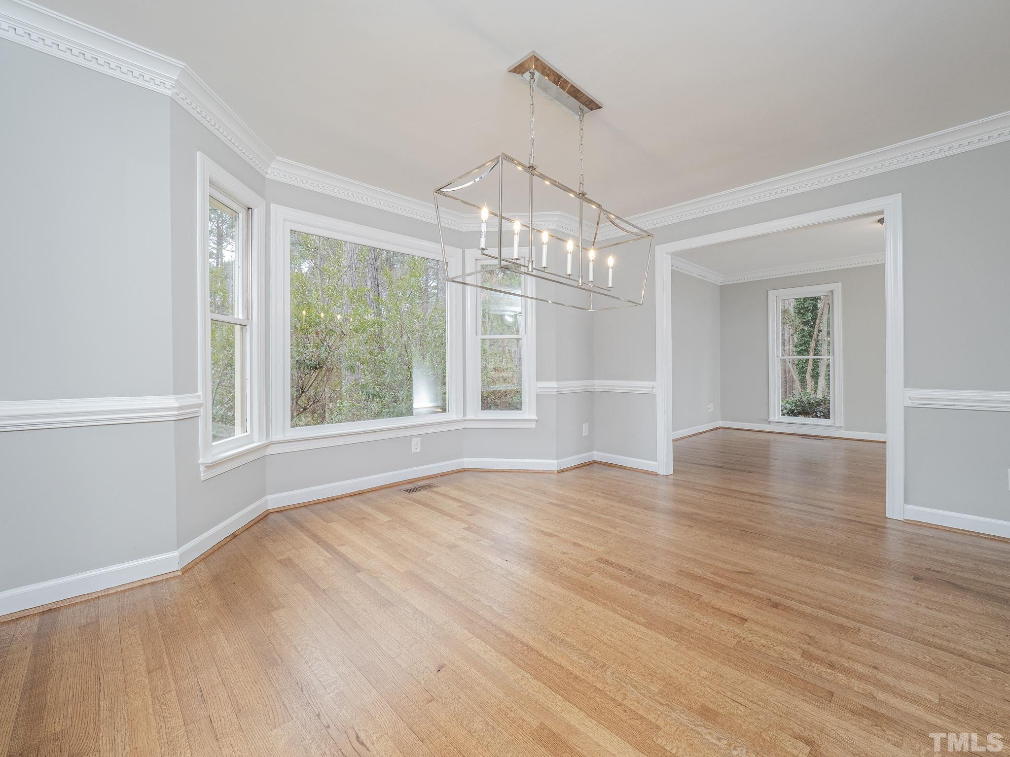 9408 Barton Creek Road Raleigh, NC 27615 - Photo 9 of 20 a view of an empty room with wooden floor and a window