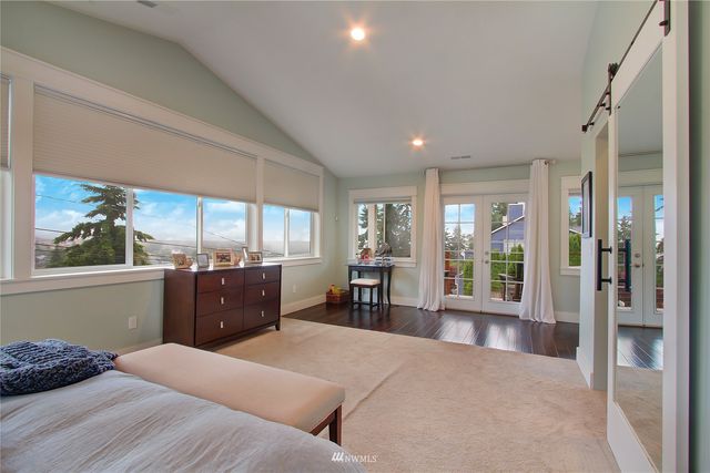 a large bedroom with a large bed and large windows