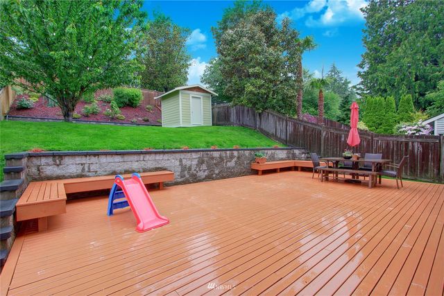 a view of a house with swimming pool and wooden fence