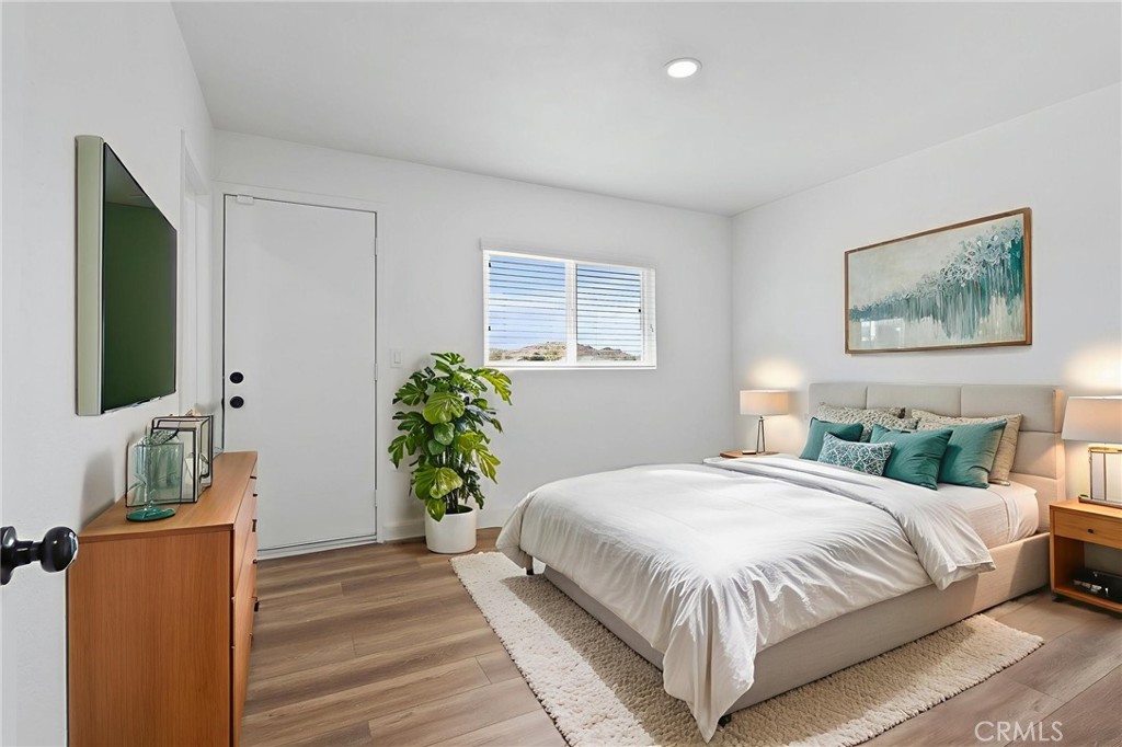 20631 Zuni Road Apple Valley, CA 92307 - Photo 15 of 25 a bedroom with a large bed and a flat screen tv