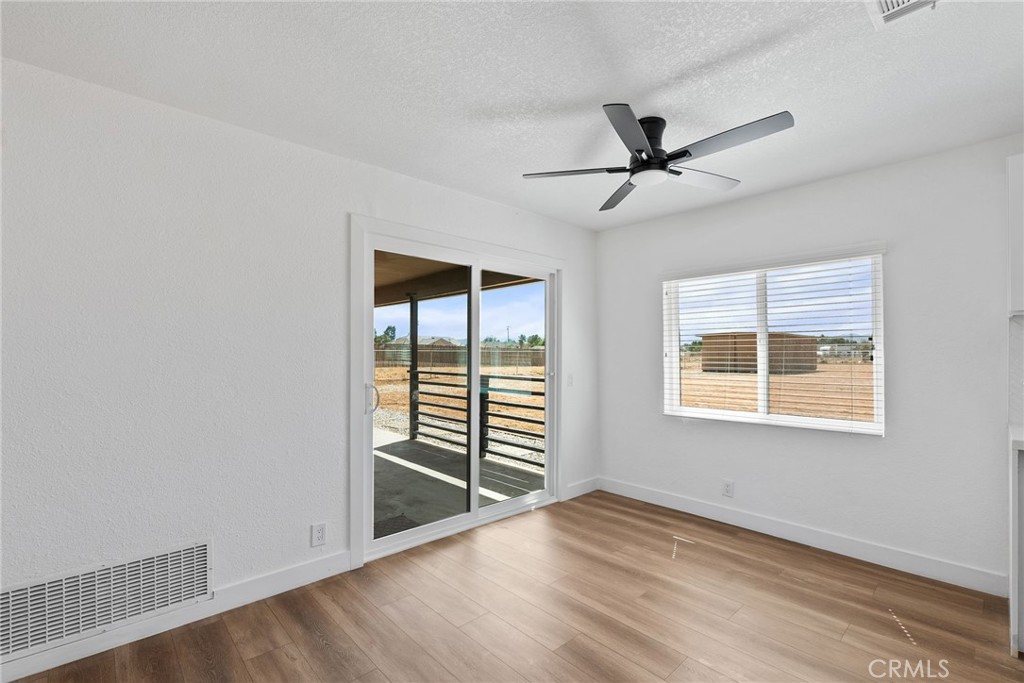 20631 Zuni Road Apple Valley, CA 92307 - Photo 8 of 25 a view of an empty room with a window and wooden floor
