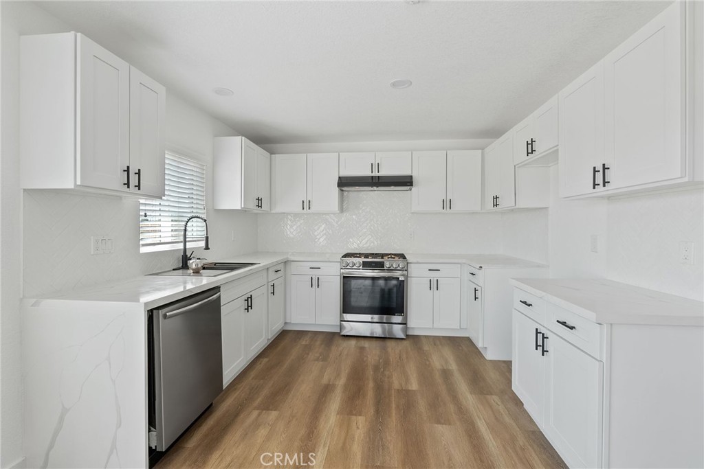 20631 Zuni Road Apple Valley, CA 92307 - Photo 10 of 25 a kitchen with granite countertop a sink stove and refrigerator