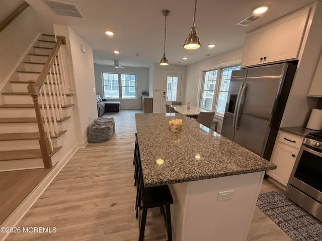 a view of a kitchen with granite countertop a stove and a wooden floor