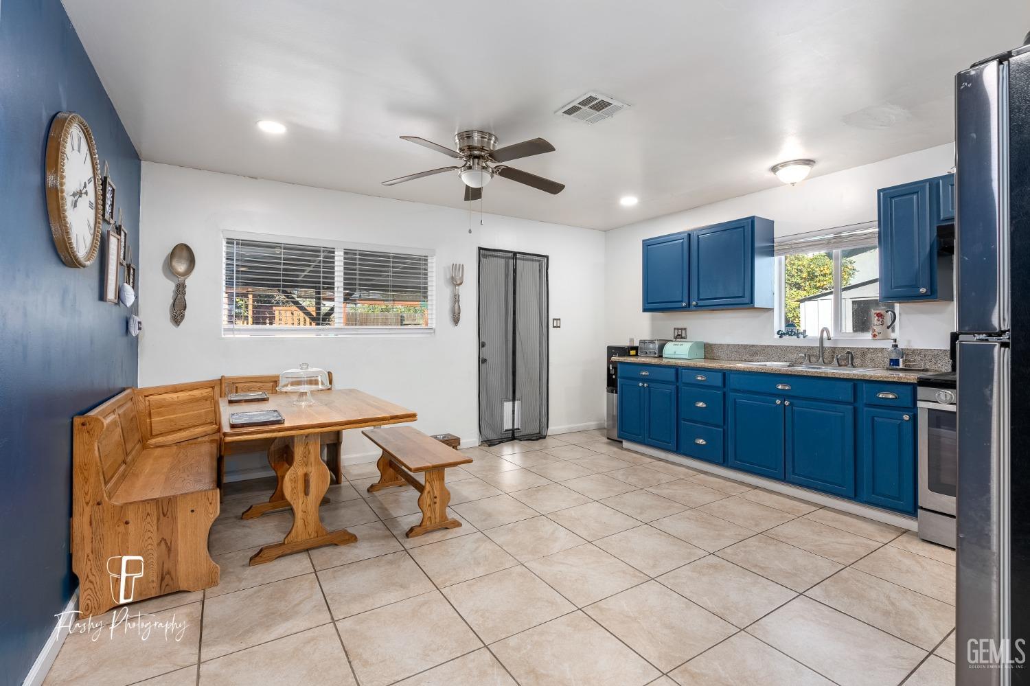 Undisclosed Address Bakersfield, CA 93304 - Photo 13 of 28 a kitchen with stainless steel appliances kitchen island granite countertop a sink dishwasher and a refrigerator with wooden cabinets