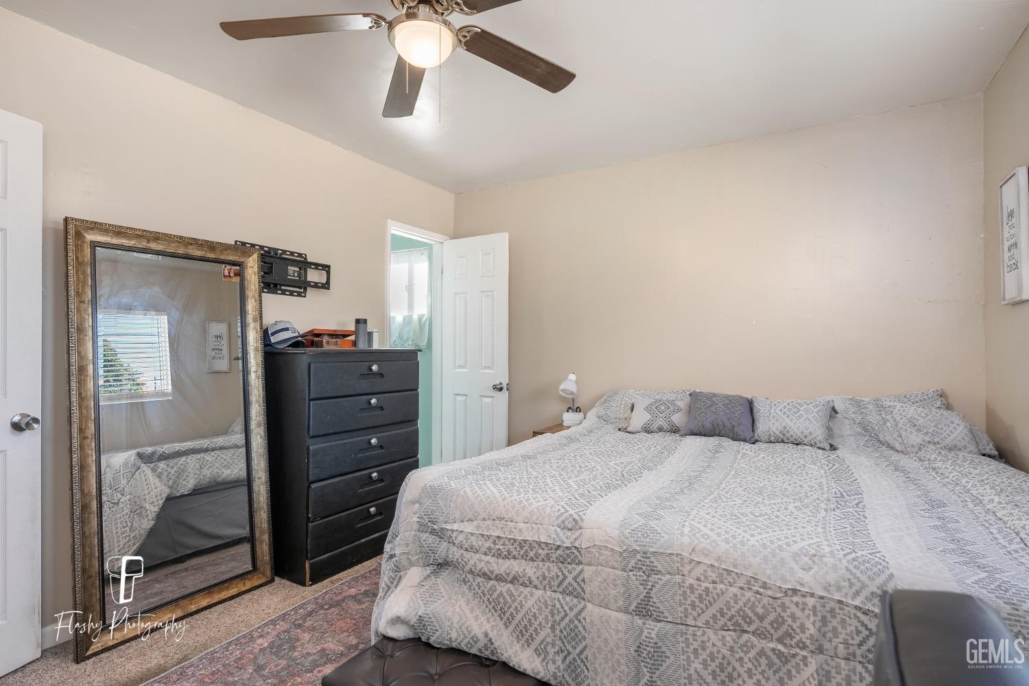 Undisclosed Address Bakersfield, CA 93304 - Photo 16 of 28 a bedroom with a bed and a chandelier