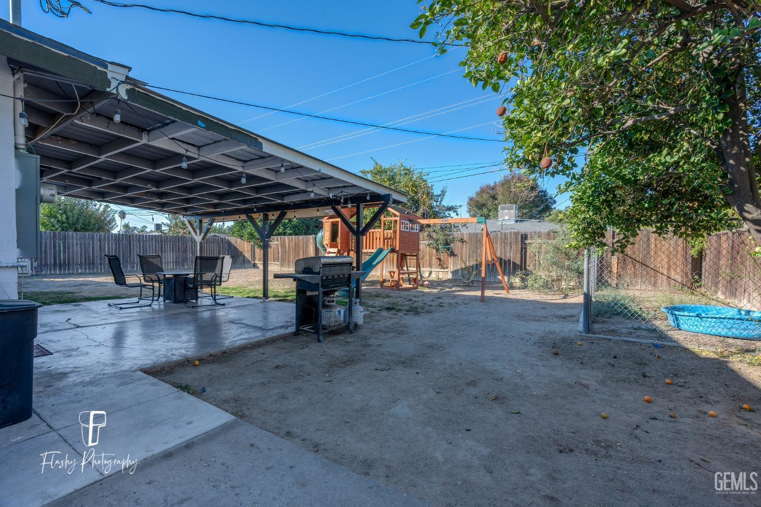 Undisclosed Address Bakersfield, CA 93304 - Photo 28 of 28 a view of a backyard with table and chairs under an umbrella