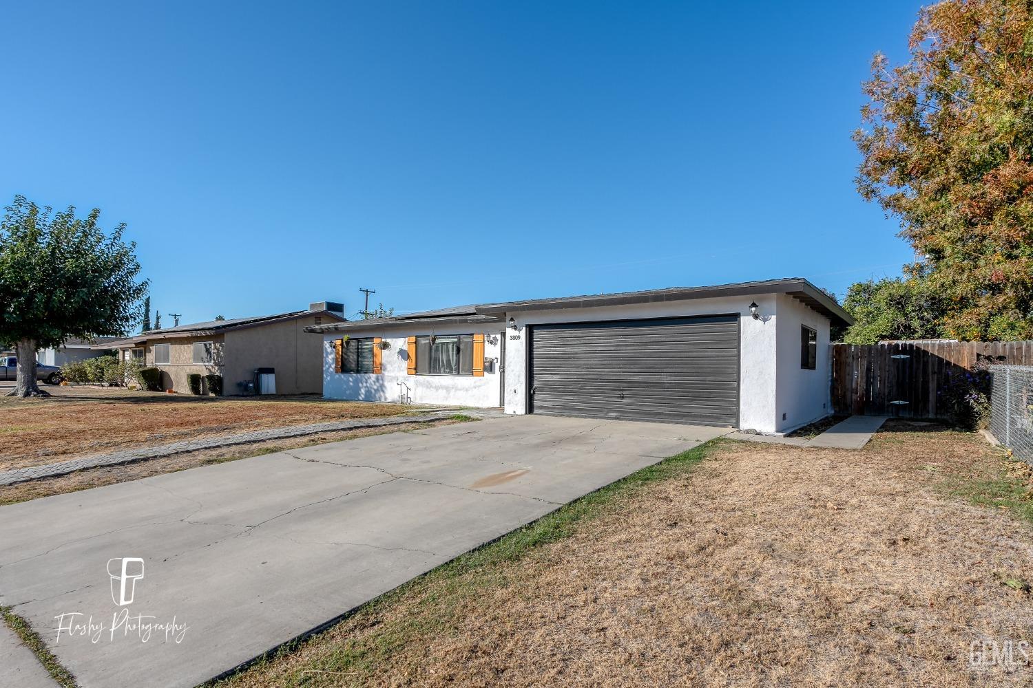 Undisclosed Address Bakersfield, CA 93304 - Photo 3 of 28 a front view of a house with a yard and garage
