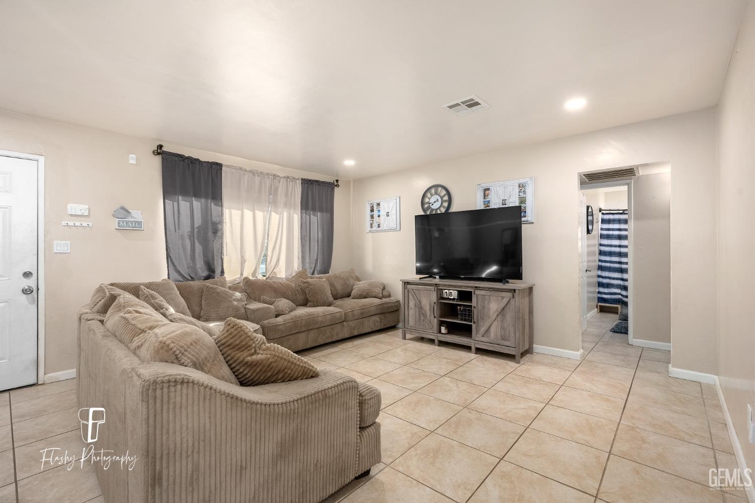 Undisclosed Address Bakersfield, CA 93304 - Photo 8 of 28 a living room with furniture and a flat screen tv