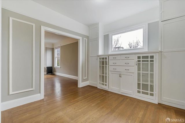 a view of a hallway with wooden floor and windows