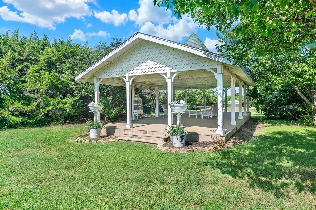 1425 Lone Star Road Celina, TX 75009 - Photo 32 of 40 The expansive covered pavilion is an inviting gathering space designed for entertaining, celebrations, or simply enjoying the peaceful country setting. With its open-air design, exposed timber framing, and generous footprint, it comfortably accommodates everything from family barbecues to special events while overlooking the beautifully maintained grounds.