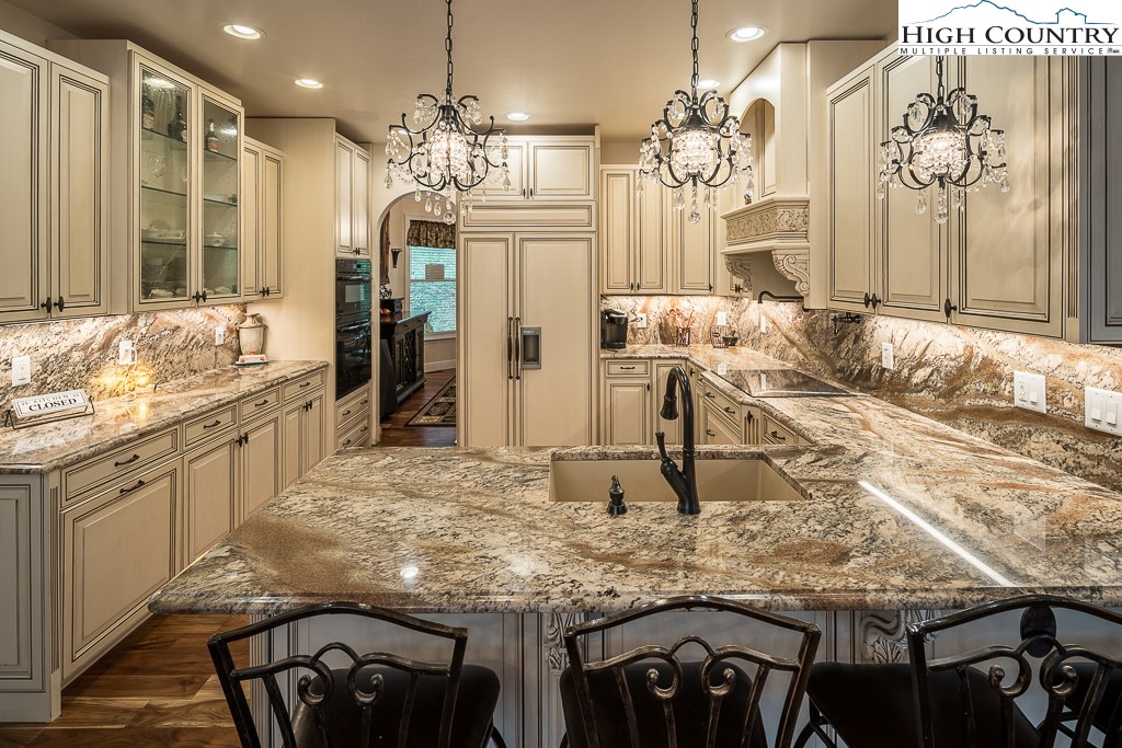 356 Upper Reach Drive Vilas, NC 28692 - Photo 9 of 49 a kitchen with kitchen island granite countertop a table chairs sink and refrigerator
