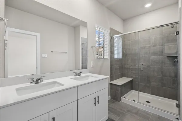a bathroom with a sink double vanity and shower