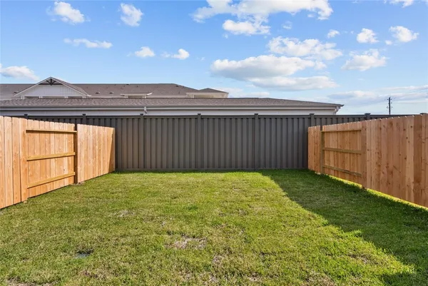 a view of a house with a yard and wooden fence