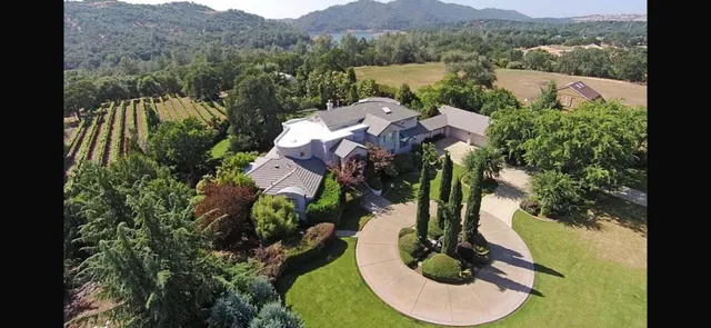 an aerial view of house with yard swimming pool and lake view
