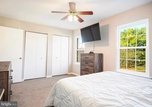 a bedroom with a bed and a flat tv screen on dresser