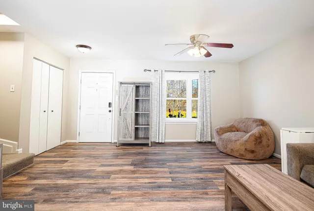 a view of a livingroom with wooden floor and a ceiling fan
