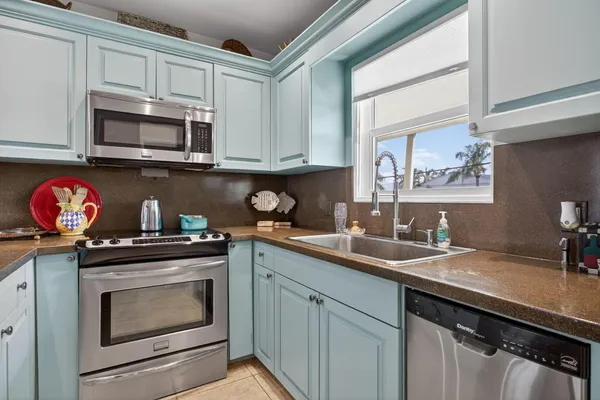 a kitchen with granite countertop a sink stove and microwave