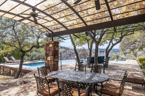 a view of a backyard with sitting area and tree