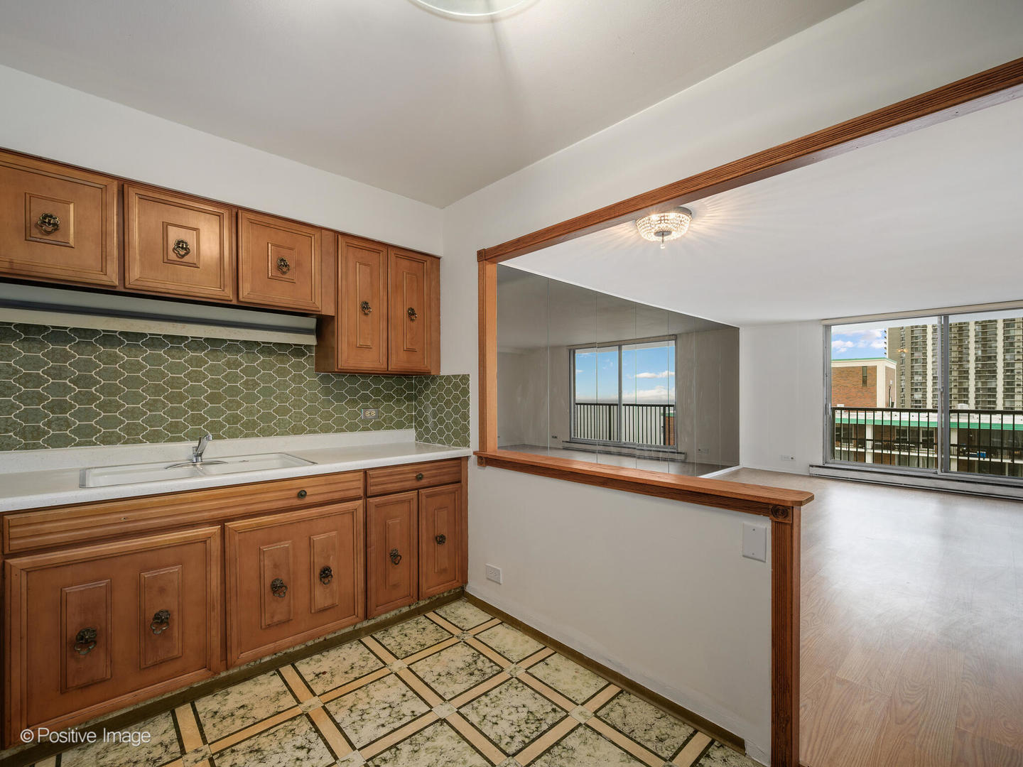 5855 North Sheridan Road, Unit 17D Chicago, IL 60660 - Photo 10 of 18 a kitchen with granite countertop a sink and cabinets