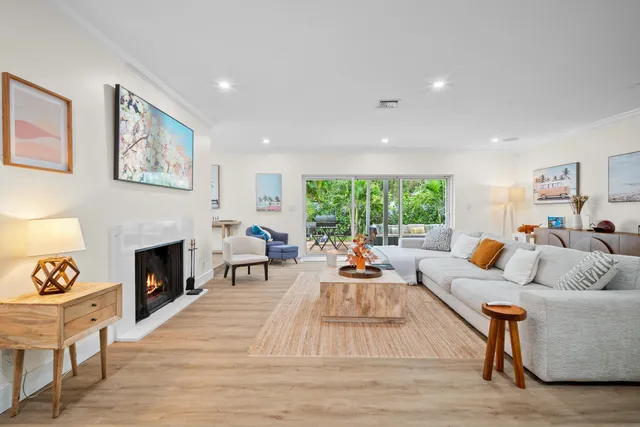 a kitchen with stainless steel appliances kitchen island granite countertop a dining table chairs and a refrigerator