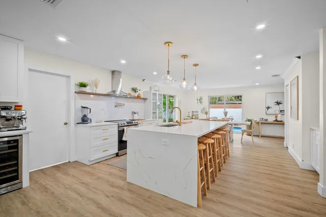 a large white kitchen with lots of counter space wooden floor and appliances