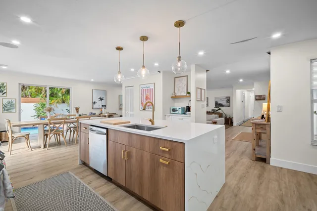 a living room with furniture and a dining table with wooden floor