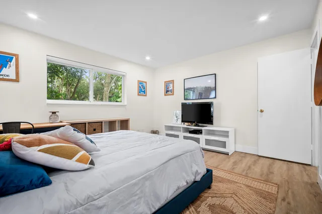 a bedroom with a bed a desk and chair next to a window