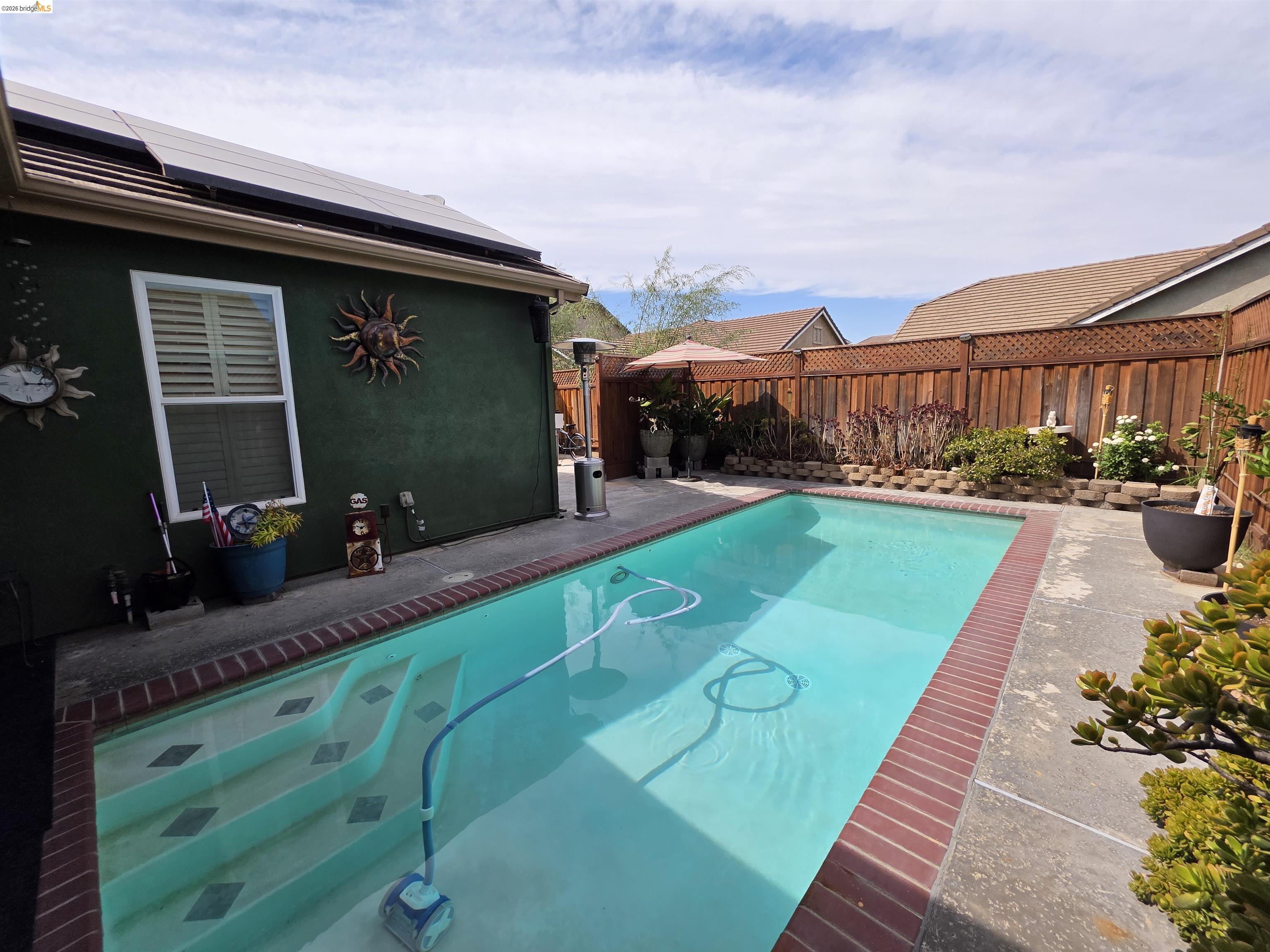 2607 Glow Road Riverbank, CA 95367 - Photo 35 of 42 In-ground pool with brick coping, concrete decking, and integrated steps