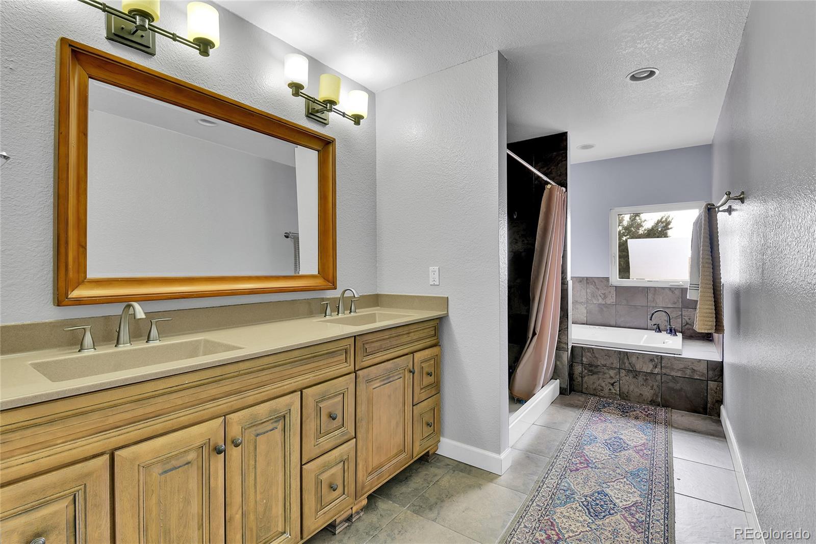 1632 Kiowa-Bennett Road Bennett, CO 80102 - Photo 15 of 42 a bathroom with a double vanity sink mirror and bathtub