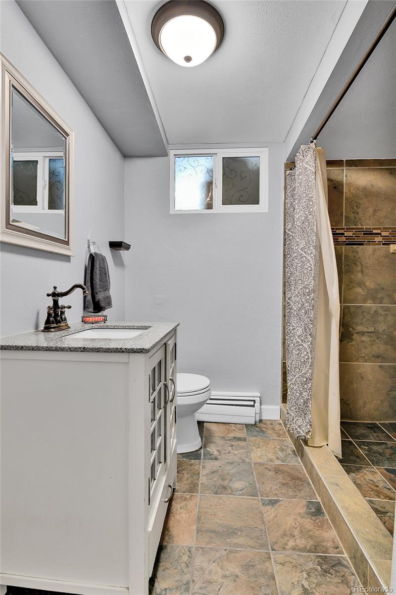 1632 Kiowa-Bennett Road Bennett, CO 80102 - Photo 21 of 42 a bathroom with a sink a toilet and shower