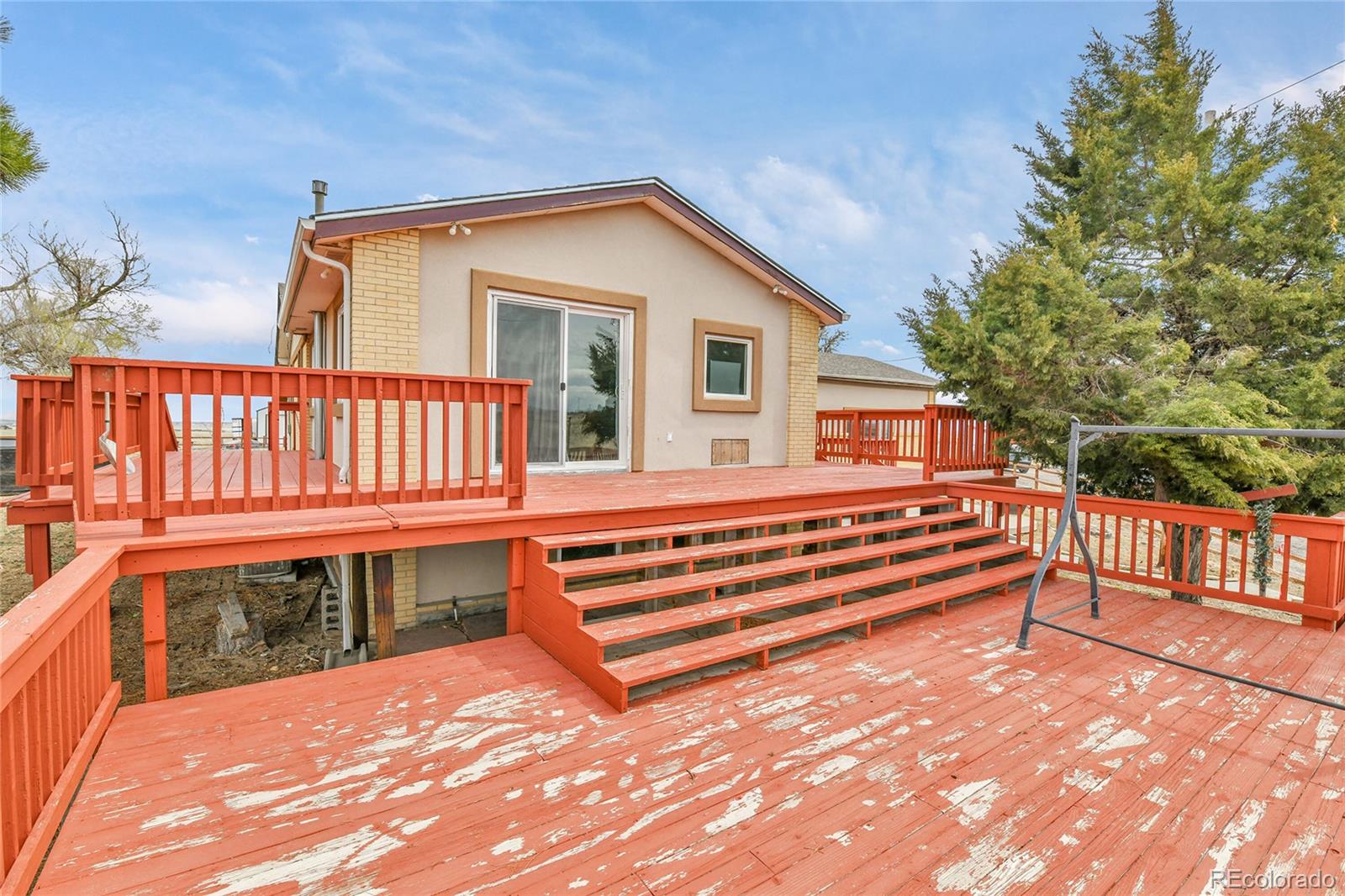 1632 Kiowa-Bennett Road Bennett, CO 80102 - Photo 30 of 42 a view of a house with wooden deck and a backyard
