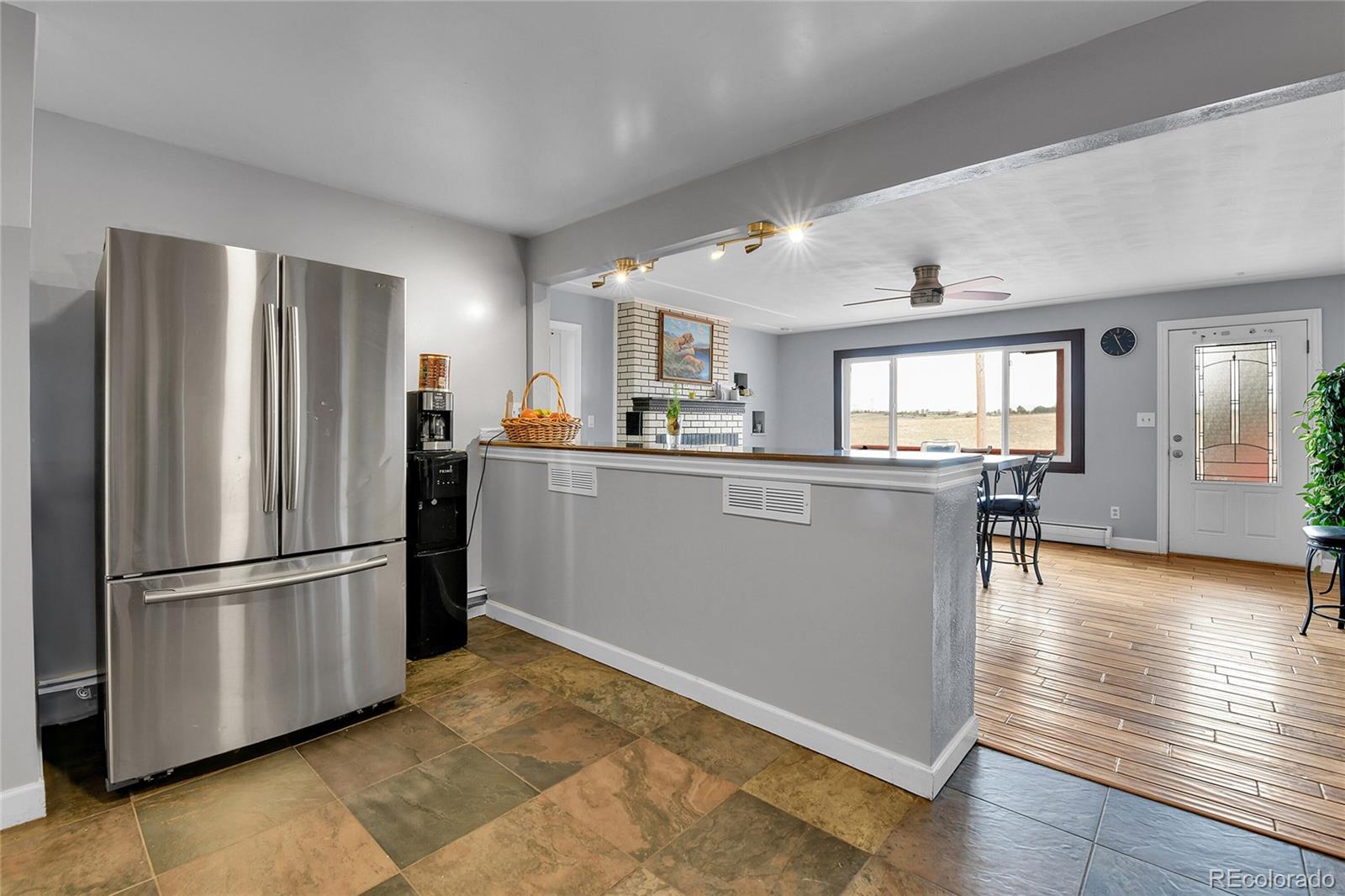 1632 Kiowa-Bennett Road Bennett, CO 80102 - Photo 7 of 42 a kitchen with stainless steel appliances granite countertop a refrigerator microwave and wooden floor