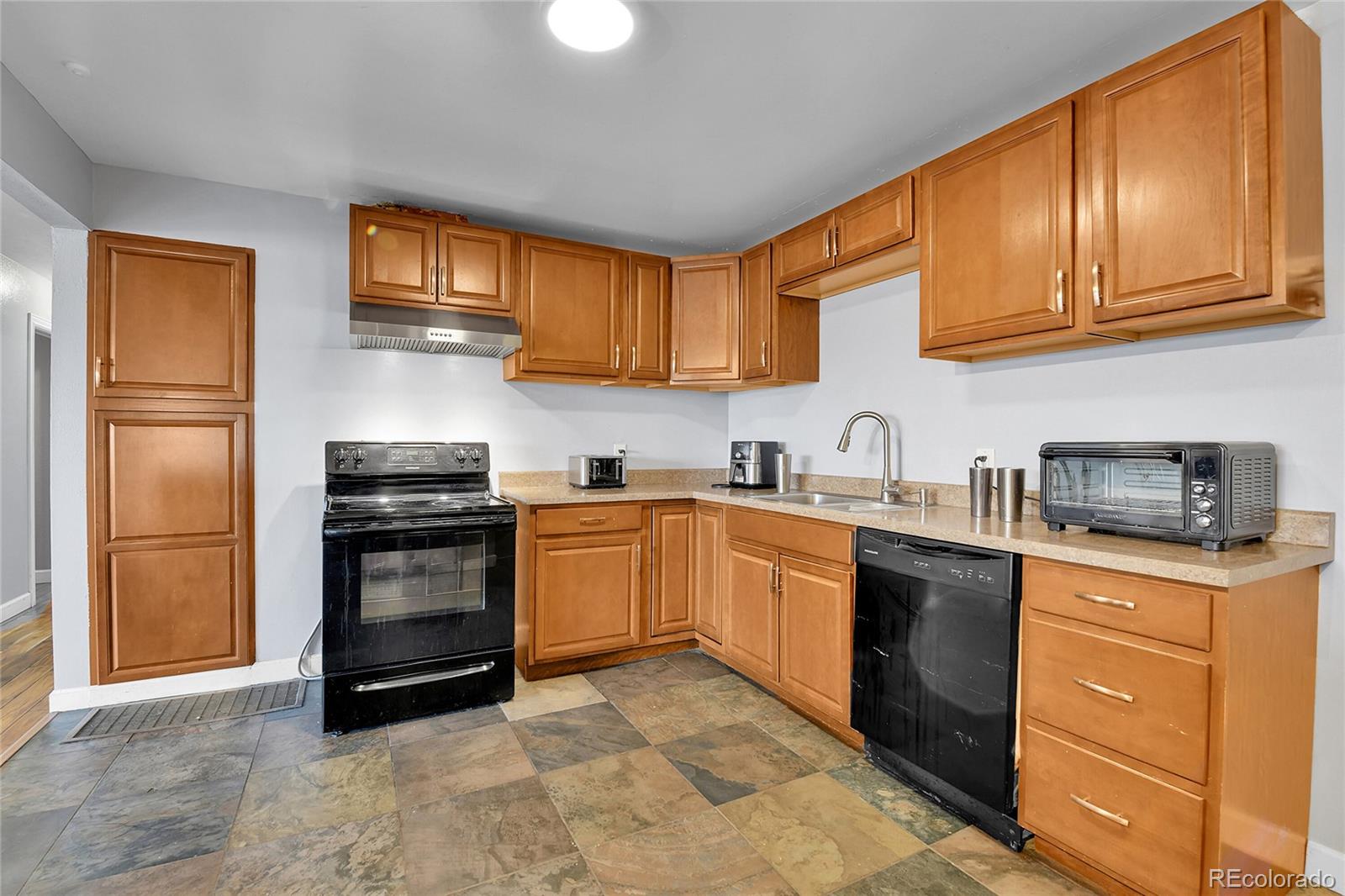 1632 Kiowa-Bennett Road Bennett, CO 80102 - Photo 8 of 42 a kitchen with stainless steel appliances granite countertop a refrigerator stove top oven and sink