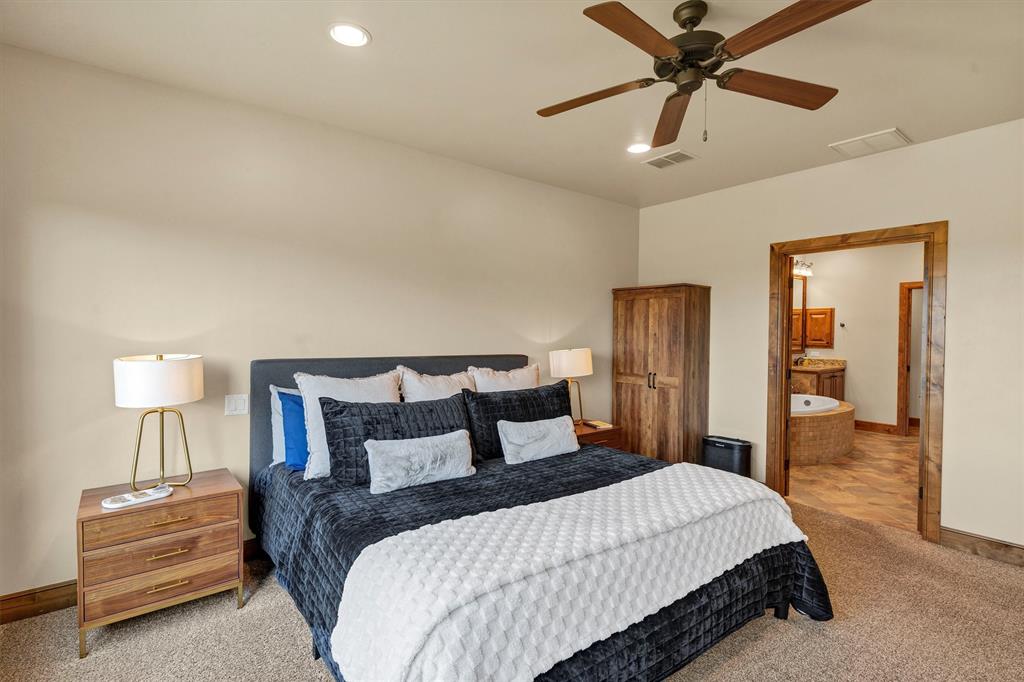 1693 Scenic Drive, Unit 101 Graford, TX 76449 - Photo 15 of 35 a bedroom with a bed and a chandelier