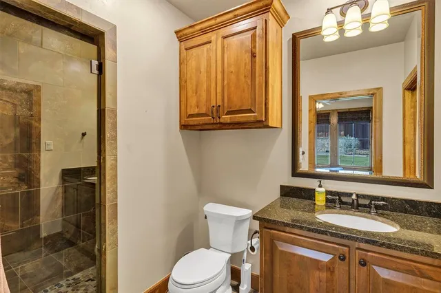 a bathroom with a granite countertop sink toilet and shower