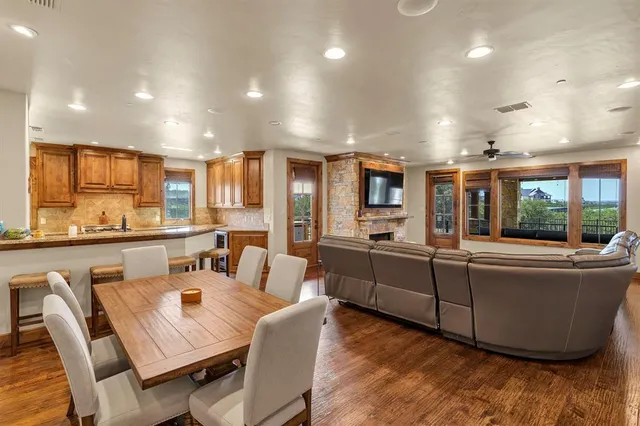 a living room with stainless steel appliances furniture large window and wooden floor