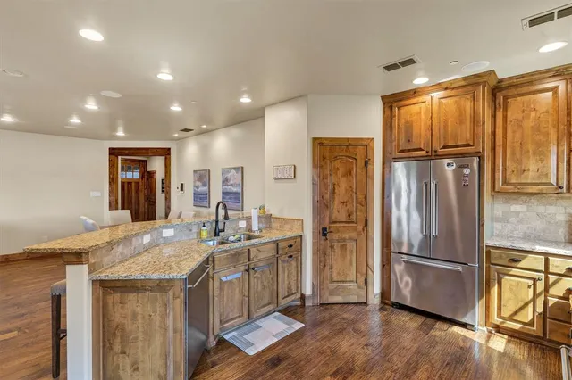 a kitchen with stainless steel appliances granite countertop a refrigerator and a sink