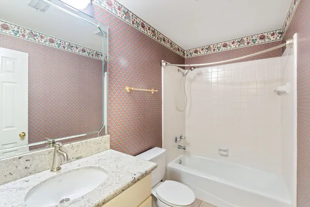 a spacious bedroom with a bed and a chandelier