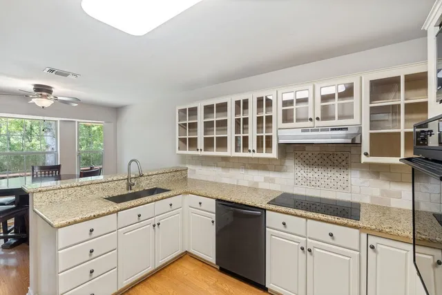 a kitchen with granite countertop a sink and white cabinets