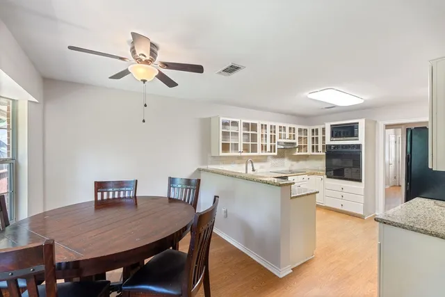 a kitchen with kitchen island a dining table and chairs