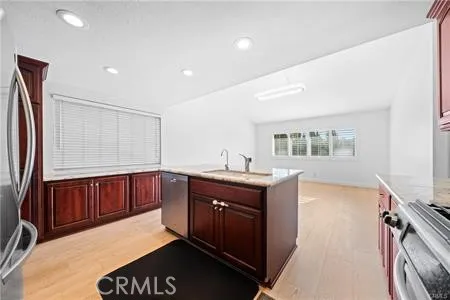 a kitchen with stainless steel appliances granite countertop a sink and wooden cabinets