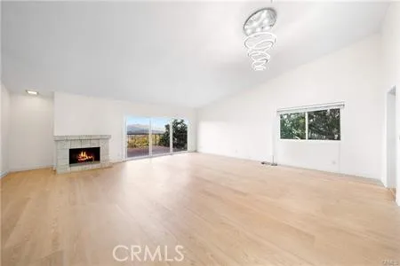an empty room with fireplace and windows