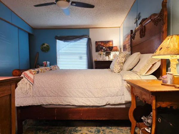 a bedroom with a bed and dresser with chair