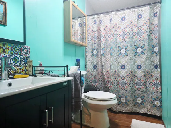 a view of bathroom with a toilet and a shower curtain