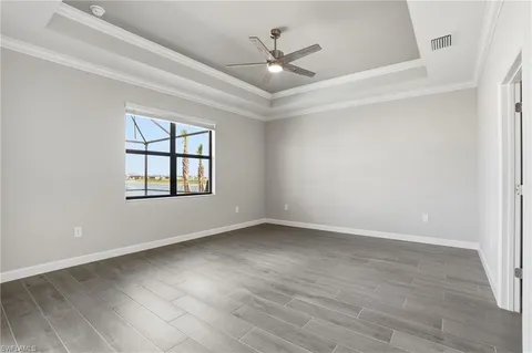 an empty room with windows and ceiling fan
