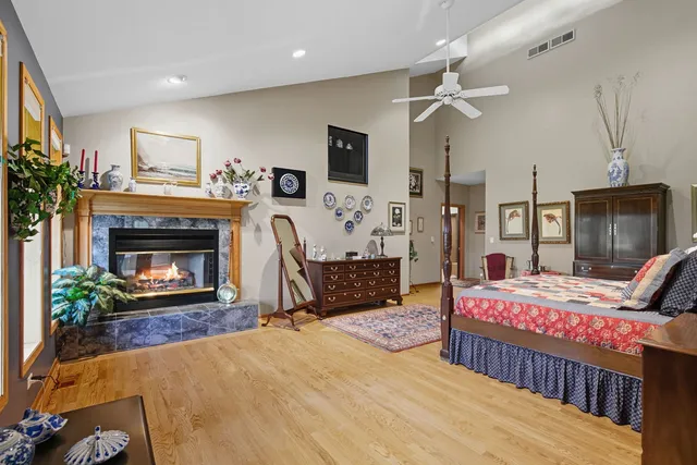 a bedroom with a bed a fireplace and a flat tv screen