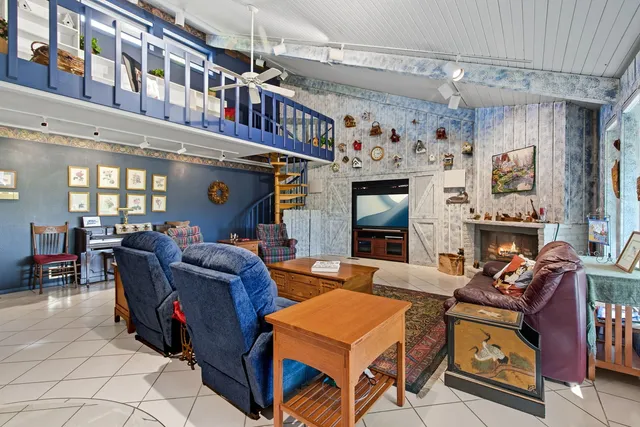 a living room with furniture a fireplace and a chandelier