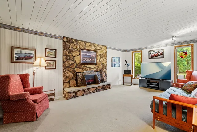 a living room with furniture a flat screen tv and a wall painting